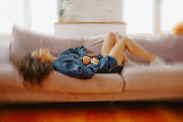 Polina Zimmerman, Pexels Imagem borrada e distorcida de uma mulher deitada sobre o sofá, com as mãos na barriga, dando a impressão de dor.